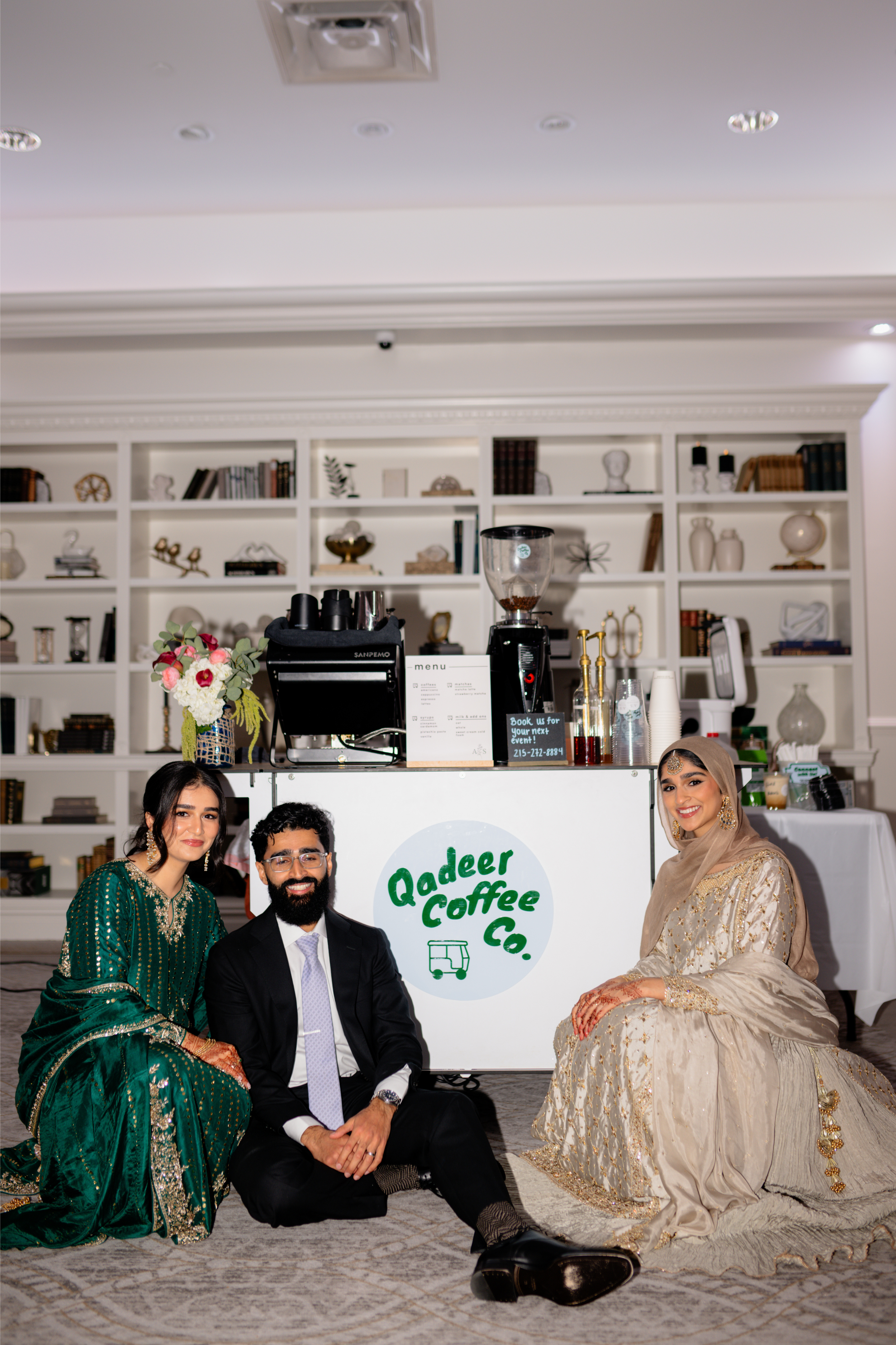 The Qadeer Coffee Co family seated in front of the mobile coffee cart