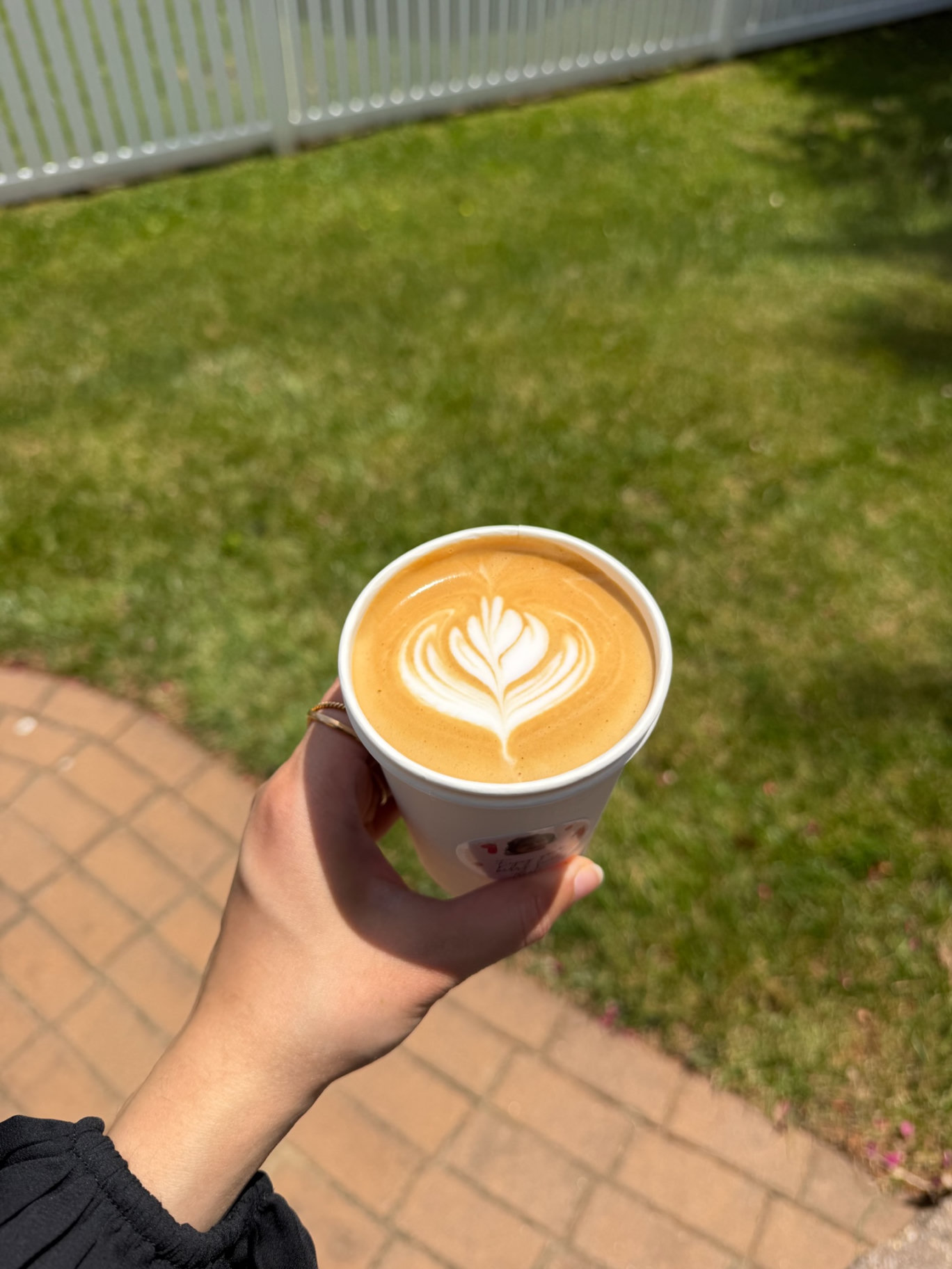 Guest holding a fresh hot latte with hand poured latte art